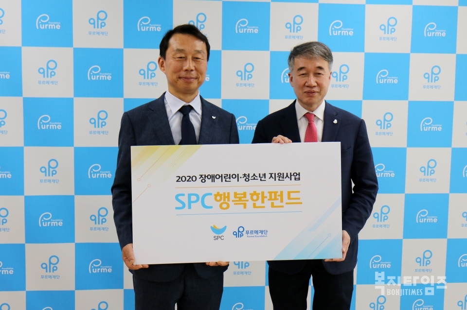 21일 김범호 SPC 부사장(사진 왼쪽)이 백경학 푸르메재단 상임이사에게 'SPC 행복한 펀드' 기금을 전달하고 있다.