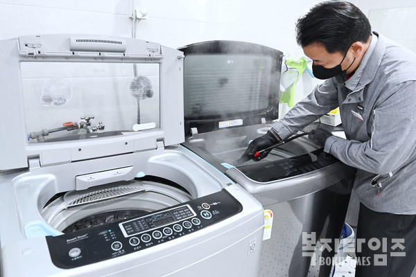 LG전자 직원이 사회복지시설에서 세탁통에 스팀을 분사하는 통살균 서비스를 진행하고 있다.