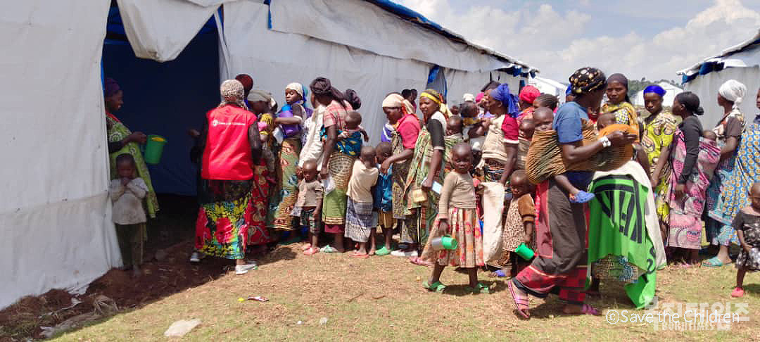 우간다 남서부 지역 냐카반데 난민경유센터에서 식량과 물자수령 기다리는 여성과 아동들(사진=세이브더칠드런)