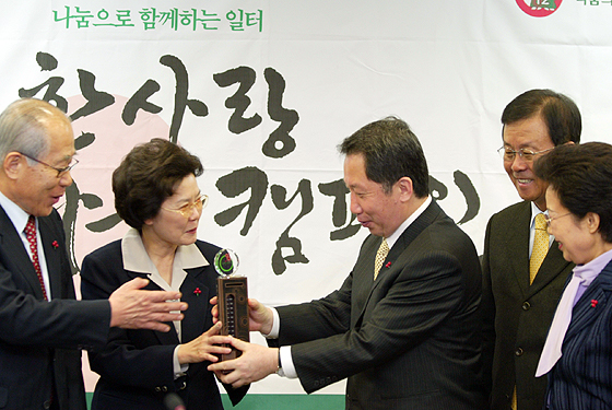 김근태 의장이 공동모금회 이세중 회장으로부터 '사랑의 열매'를 전달 받고 있다.