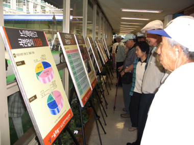 노인학대예방 캠페인에 참가한 어르신들이 포스터를 살펴보고 있다.(자료: 서울시노인학대예방센터)