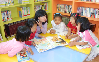 아이들과 함께 할 때 가장 행복하고 보람을 느낀다는 엄미경 씨(가운데). 지역사회 전문도서관으로 자리매김한 초지어린이도서관에서 어린이들과 독서토론을 하고 있다. 